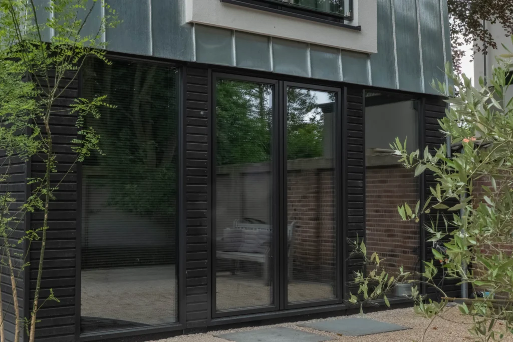 Moderne hoekwoning met grote zwarte glaspartijen